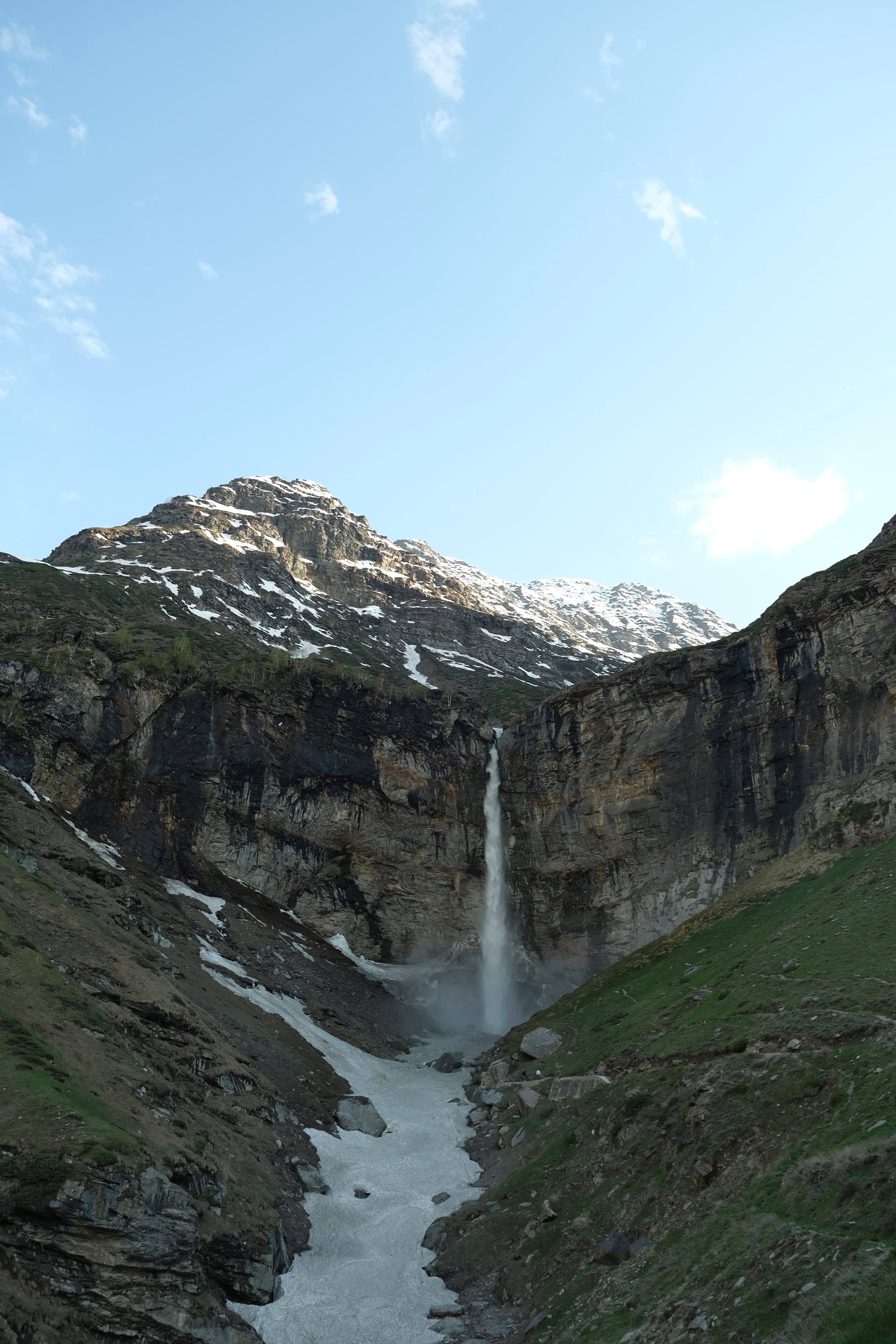 Waterfall tumbling from a snow-lined cliff in the Himalayas