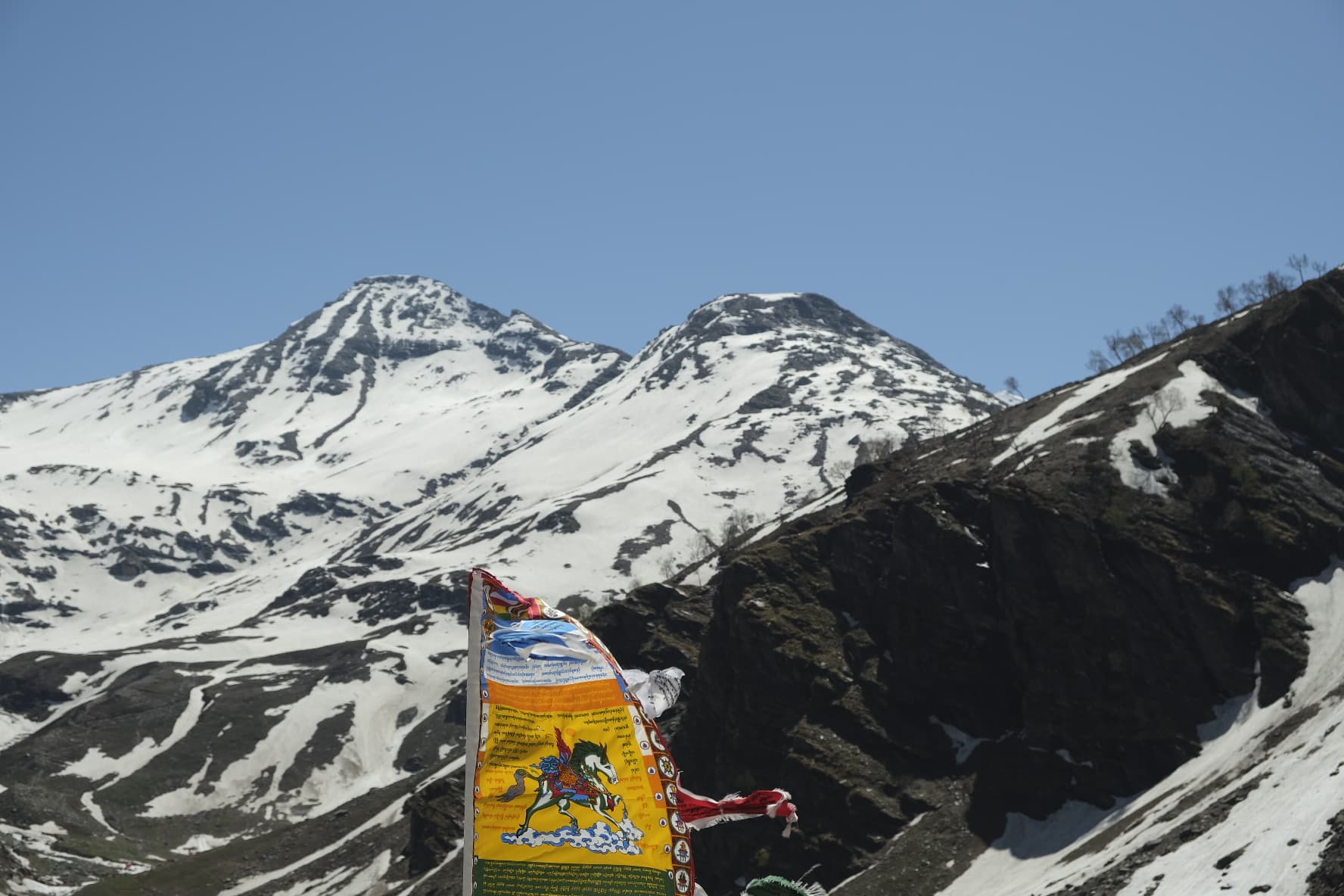 Colorful Buddhist prayer flags strung against snow-capped Himalayan peaks